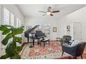 Bright living room featuring a grand piano, hardwood floors, and a ceiling fan for a cozy atmosphere at 26404 E Caley Dr, Aurora, CO 80016