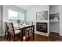 Cozy dining area features hardwood floors, a fireplace, and a large window for natural light at 1451 S Quitman St, Denver, CO 80219