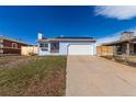 Inviting home with a spacious driveway, showcasing a neat lawn and classic suburban appeal on a sunny day at 1451 S Quitman St, Denver, CO 80219