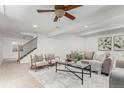 Bright living room featuring neutral decor, plush seating, and a staircase leading to the upper level at 1451 S Quitman St, Denver, CO 80219