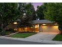 Inviting exterior view of a home featuring a brick facade, attached garage, and lush landscaping at 3190 S Detroit St, Denver, CO 80210