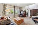 Bright living room featuring large windows, hardwood floors, piano, neutral colors, and stylish furniture at 860 Quintana Ln, Erie, CO 80516
