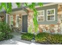Inviting entrance with stone facade, a gray front door, and lush landscaping at 10223 Vine Ct, Thornton, CO 80229