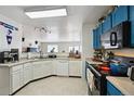Well-lit kitchen featuring white cabinets, modern appliances, and a pass-through to the adjacent living space at 10223 Vine Ct, Thornton, CO 80229