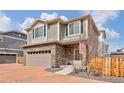 Charming two-story home with a stone-clad facade and an attached two-car garage at 203 S Oak Hill St, Aurora, CO 80018