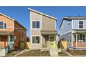 Two-story modern home with gray siding, yellow porch, and landscaping at 10251 E 62Nd Pl, Denver, CO 80238