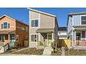 Two-story modern home with gray siding, yellow porch, and landscaping at 10251 E 62Nd Pl, Denver, CO 80238