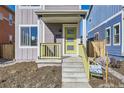 Modern home's front porch with yellow railing and door at 10251 E 62Nd Pl, Denver, CO 80238