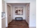 Inviting foyer with wood floors, neutral paint, a modern bench, and tasteful abstract art at 14546 Pine View Rd, Larkspur, CO 80118