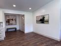 Elegant entryway with wood floors, neutral paint, stylish bench, and sophisticated artwork on the walls at 14546 Pine View Rd, Larkspur, CO 80118