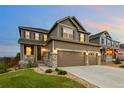 Attractive home featuring a three-car garage, covered porch, and landscaped front yard at 7734 Blue Water Dr, Castle Rock, CO 80108