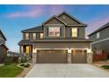 Charming two-story home with a three-car garage and well-manicured lawn at 7734 Blue Water Dr, Castle Rock, CO 80108