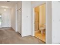 Hallway featuring neutral tones, closet, and bathroom with tiled floors and glass door shower at 10725 Eliot Cir # 102, Denver, CO 80234