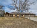 Ranch-style house featuring a front lawn with a basketball hoop and a three-car garage at 15955 W 52Nd Dr, Golden, CO 80403
