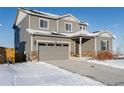 Charming two-story home with a large gray garage door, front porch, and snowy landscaping at 6612 Merrimack Dr, Castle Pines, CO 80108