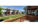 Community view from this townhome's deck with wood railings overlooking the grassy common area at 4220 E 119Th Pl # A, Thornton, CO 80233