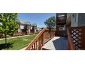 Inviting outdoor deck with wood railings, perfect for relaxation and enjoying the community's beautiful green spaces at 4220 E 119Th Pl # A, Thornton, CO 80233