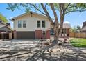 Charming two-story home with brick accents, attached garage, mature tree, and well-maintained lawn at 3832 S Quebec St, Denver, CO 80237