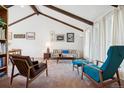 Bright living room featuring vaulted ceilings, exposed beams, neutral tones, and lots of natural light at 3832 S Quebec St, Denver, CO 80237