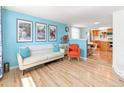 Bright living room featuring wood floors, modern furnishings, and an open layout to the kitchen at 4163 S Decatur St, Englewood, CO 80110
