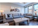 Bright living room with a gray sectional sofa, stylish coffee table, and mountain-themed artwork at 2870 W Parkside Pl, Denver, CO 80221