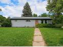 Single-story home with a walkway leading to an inviting wooden front door at 1694 S Elm St, Denver, CO 80222