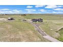 Expansive property featuring a home, outbuildings, circular driveway, and surrounding green fields at 7600 Patrick Trl, Elizabeth, CO 80107