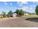 Large backyard showing house, driveway, shed, and open space at 9576 E 147Th Pl, Brighton, CO 80602