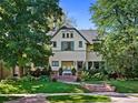 Lovely home with lush green lawn, mature trees, and classic architectural details at 141 N Gilpin St, Denver, CO 80218