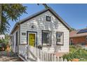 Charming home with a yellow front door, white siding, and a neatly maintained front yard at 4883 Perry St, Denver, CO 80212