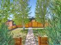 Charming front yard with a concrete walkway, a new fence, and lush green trees at 170 W Midway Blvd, Broomfield, CO 80020