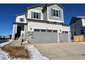 Two-story home with gray siding, two-car garage, and landscaping at 17751 E 93Rd Ave, Commerce City, CO 80022