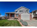 Charming two-story home featuring a brick and gray exterior, with a covered porch and well-manicured lawn at 6271 Mcintyre Way, Golden, CO 80403