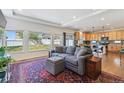 Spacious living room open to the kitchen, featuring hardwood floors, a comfortable sofa, and large windows overlooking the backyard at 1160 Acadia Cir, Erie, CO 80516