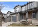 Attractive gray two-story townhouse showing the front entrance, garage, and stone accents at 2005 E 103Rd Ave, Thornton, CO 80229