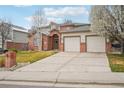 Charming two-story brick home with a well-maintained lawn and two-car garage at 6281 Mcintyre Way, Golden, CO 80403