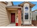 Inviting front entrance with a red door, brick pillar, and decorative fleur-de-lis accent at 5075 Weeping Willow Cir, Highlands Ranch, CO 80130