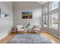 Bright living room featuring large windows, artwork, and cozy seating arrangement at 5075 Weeping Willow Cir, Highlands Ranch, CO 80130