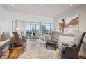 Bright living room with modern furniture, hard wood floors, neutral colors, and city views at 1201 N Williams St # 4C, Denver, CO 80218