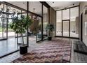 Welcoming building lobby with brick floor and walls, interior foliage, and glass doors at 1201 N Williams St # 4C, Denver, CO 80218