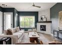 Bright living room featuring a stone fireplace, a large window, and comfortable seating area at 3473 Beeler St, Denver, CO 80238