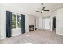 Bright living room with vaulted ceiling, gas fireplace, and large picture window with dark curtains at 4076 S Carson St # H, Aurora, CO 80014