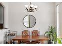 Dining room with a wooden table, patterned chairs, a round mirror, and modern chandelier at 2100 N Humboldt St # 208, Denver, CO 80205