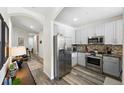 Modern kitchen with stainless steel appliances, granite countertops, mosaic backsplash, and sleek cabinets at 2100 N Humboldt St # 208, Denver, CO 80205
