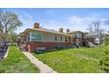 Brick two-story home featuring a well-maintained lawn and sidewalk leading to the front entrance at 5012 W 36Th Ave # 5, Denver, CO 80212