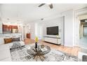 Modern living room with hardwood floors, TV, an open kitchen, and natural light at 1699 N Downing St # 302, Denver, CO 80218