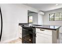 Modern kitchen featuring a black stovetop, gray countertop, and white cabinets at 600 Manhattan Dr # 4C, Boulder, CO 80303