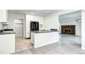 Open kitchen with white cabinets, gray countertop, black refrigerator, and view to a living room fireplace at 600 Manhattan Dr # 4C, Boulder, CO 80303