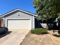 Gray house with a white garage door and driveway at 3611 S Ouray Cir, Aurora, CO 80013