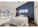 Serene bedroom featuring a stylish accent wall, large window, and comfortable bed at 2541 S Bahama Cir # F, Aurora, CO 80013